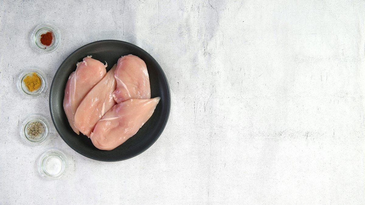 Raw chicken breasts in a bowl